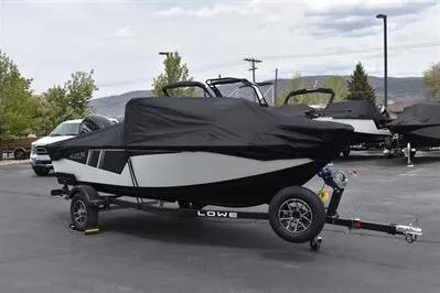 Slide: The Image of 2026 Lowe Fishing Machine 1675 WT boat covered on trailer in parking lot. - 35