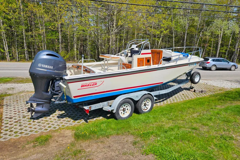 Slide: The Image of 1990 Boston Whaler OUTRAGE CUDDY boat on trailer with Yamaha engine, parked outdoors. - 7
