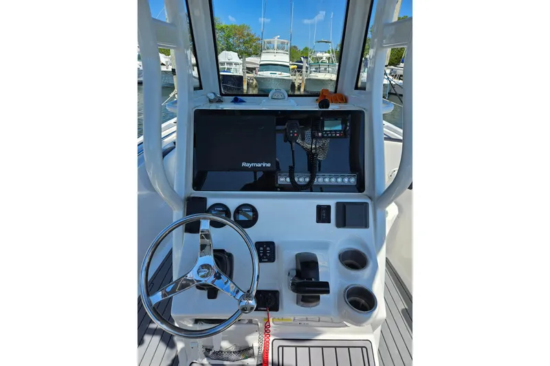 Slide: The Image of Tidewater 2023 boat dashboard with steering wheel, Raymarine display, and control panel. - 3