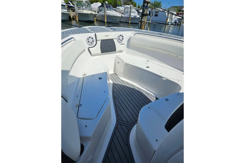 Slide: The Image of 2023 Tidewater boat interior with seating and speakers, docked at a marina. - 6
