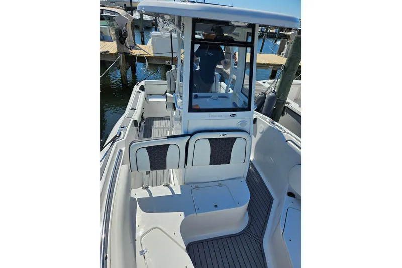 Slide: The Image of 2023 Tidewater boat interior with seating and helm, docked at marina. - 8