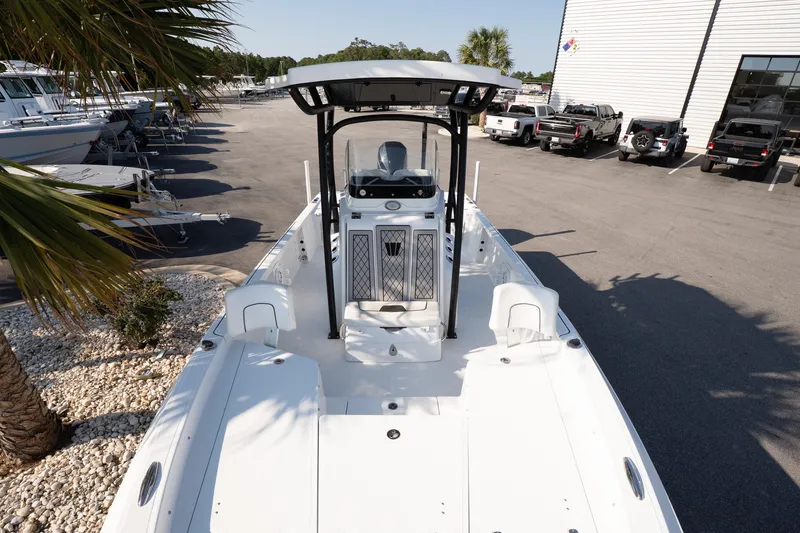 Slide: The Image of 2022 Wellcraft 241 Bay boat in a marina, surrounded by parked vehicles and palm trees. - 11