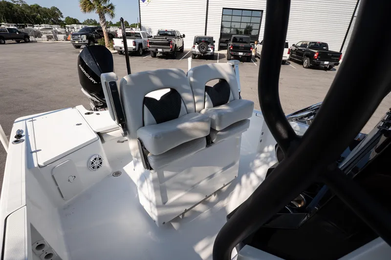 Slide: The Image of 2022 Wellcraft 241 Bay boat interior with seating and outboard motor in a parking lot. - 12