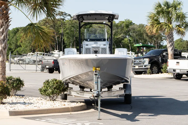 Slide: The Image of 2022 Wellcraft 241 Bay boat on trailer, parked near palm trees in a lot. - 3