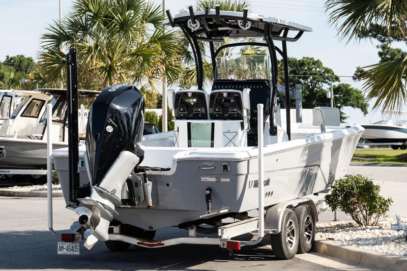Slide: The Image of 2022 Wellcraft 241 Bay boat on trailer, parked outdoors with palm trees in background. - 6