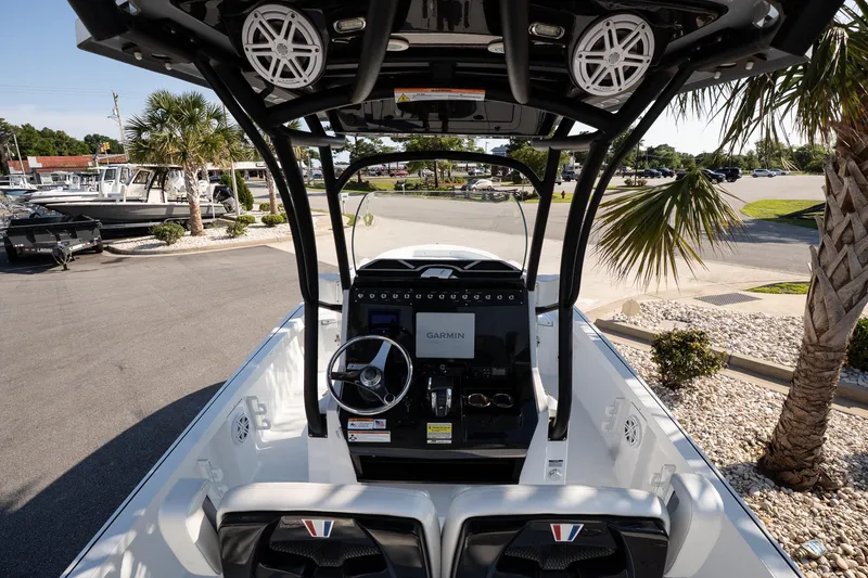 Slide: The Image of 2022 Wellcraft 241 Bay boat interior with Garmin navigation, parked near palm trees. - 8