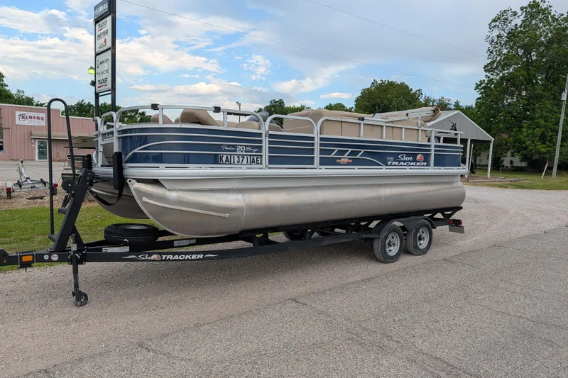 The Image of 2023 Sun Tracker Fishin' Barge 20 DLX pontoon boat on trailer, parked outdoors. - 29