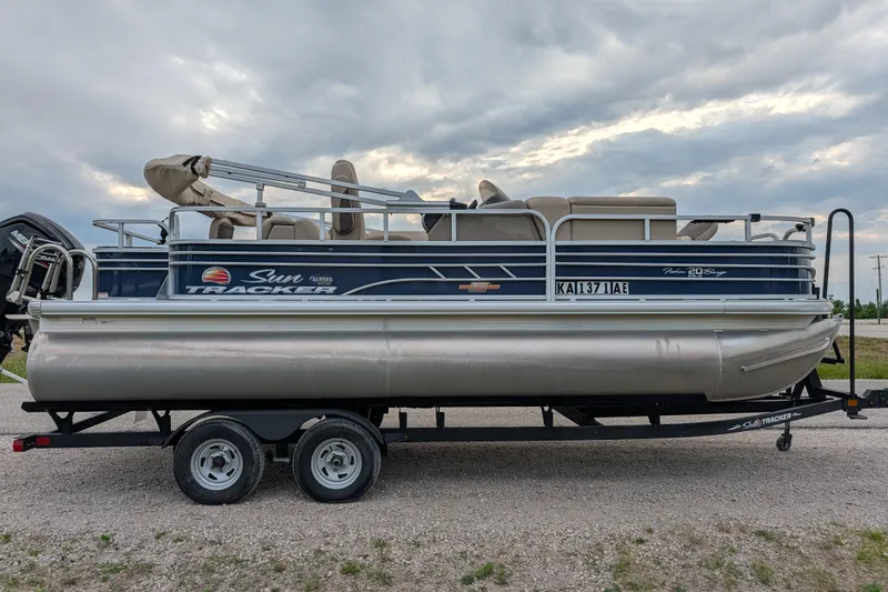 Slide: The Image of 2023 Sun Tracker Fishin' Barge 20 DLX pontoon boat on trailer, side view. - 34