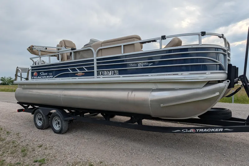 Slide: The Image of 2023 Sun Tracker Fishin' Barge 20 DLX pontoon boat on trailer, parked outdoors. - 35