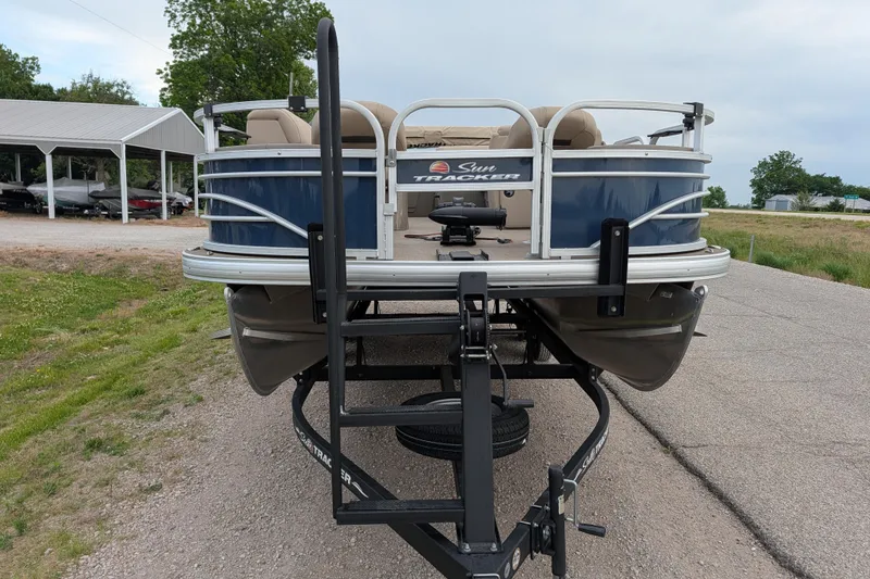 Slide: The Image of 2023 Sun Tracker Fishin' Barge 20 DLX pontoon boat on trailer, parked outdoors. - 36