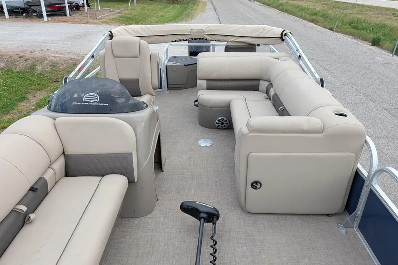 Slide: The Image of 2023 Sun Tracker Fishin' Barge 20 DLX interior with beige seating and helm. - 37