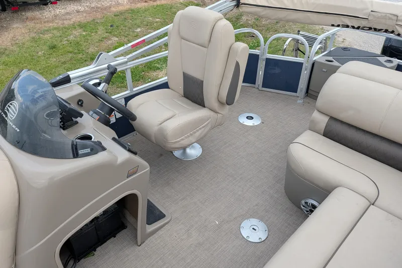 Slide: The Image of 2023 Sun Tracker Fishin' Barge 20 DLX interior with beige seating and steering console. - 40