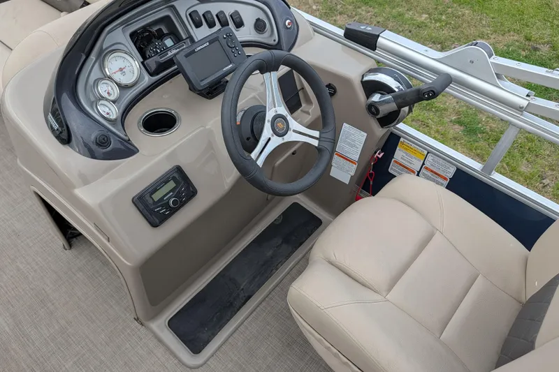 Slide: The Image of 2023 Sun Tracker Fishin' Barge 20 DLX helm with steering wheel, gauges, and comfortable seating. - 41