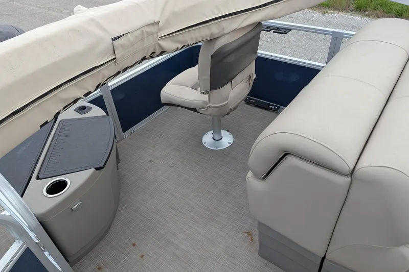 Slide: The Image of 2023 Sun Tracker Fishin' Barge 20 DLX interior with beige seating and fishing station. - 42