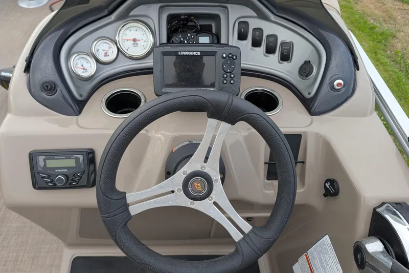 Slide: The Image of 2023 Sun Tracker Fishin' Barge 20 DLX dashboard with steering wheel, gauges, and navigation system. - 45
