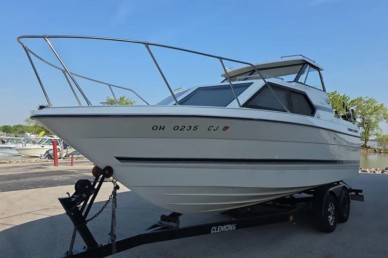 Slide: The Image of 1999 Bayliner 2452 Ciera Express boat on trailer, parked outdoors under clear sky. - 1
