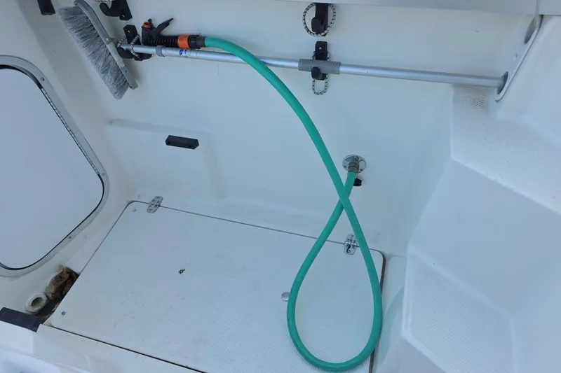 Slide: The Image of 1999 Bayliner 2452 Ciera Express deck with hose and cleaning brush. - 10