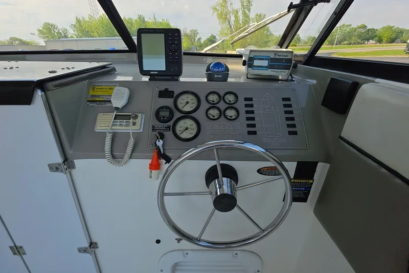 Slide: The Image of 1999 Bayliner 2452 Ciera Express helm with steering wheel and navigation instruments. - 17