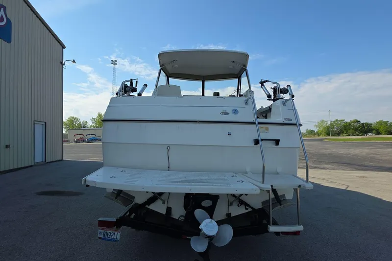Slide: The Image of 1999 Bayliner 2452 Ciera Express boat, rear view, parked outdoors on a sunny day. - 4