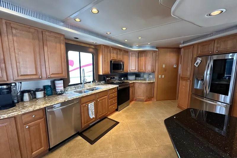 Slide: The Image of Luxurious kitchen in a 2004 Sumerset 18x96 houseboat with modern appliances and wooden cabinetry. - 4