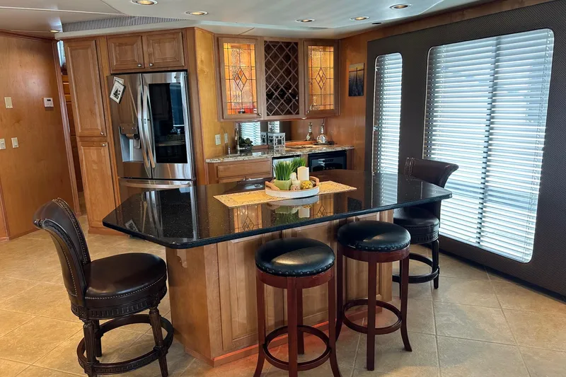 Slide: The Image of Luxurious 2004 Sumerset 18x96 houseboat kitchen with granite island, bar stools, and stainless steel appliances. - 5