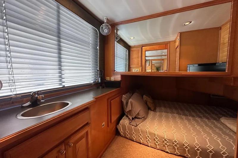 Slide: The Image of Cozy bedroom interior of 2004 Sumerset 18x96 houseboat with bed, sink, and wooden cabinetry. - 9