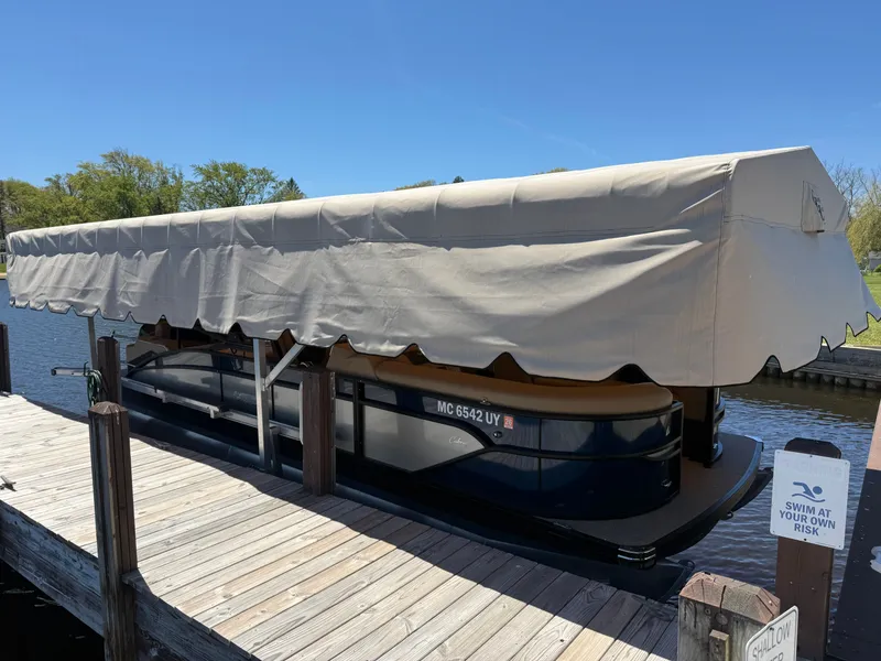 Slide: The Image of 2024 Barletta Cabrio 24 UETT pontoon boat docked. - 1