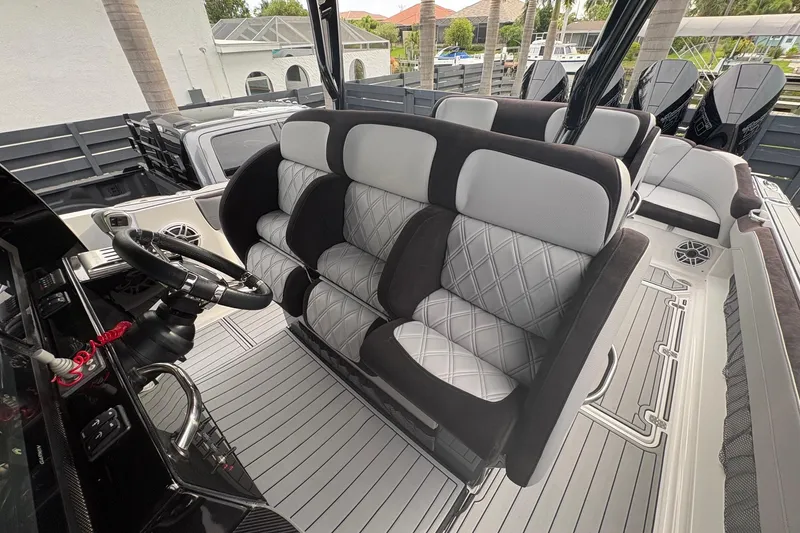 Slide: The Image of 2024 Nor-Tech 390 Sport Center Console interior with luxurious seating and modern steering console. - 16