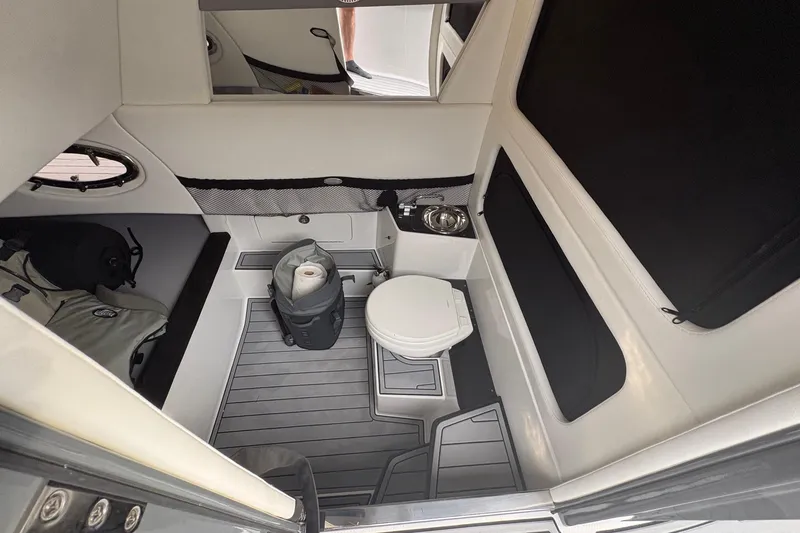 Slide: The Image of 2024 Nor-Tech 390 Sport Center Console cabin interior with toilet and storage space. - 27