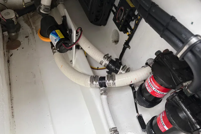 Slide: The Image of Engine compartment of 2024 Nor-Tech 390 Sport Center Console with hoses and filters. - 29
