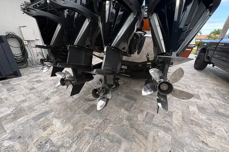 Slide: The Image of 2024 Nor-Tech 390 Sport Center Console with triple outboard engines and stainless steel propellers. - 33