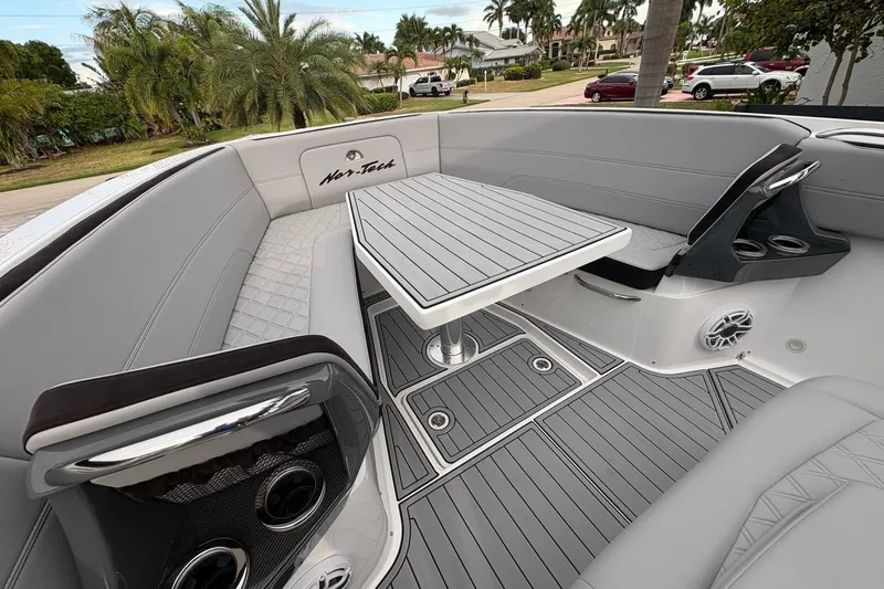 Slide: The Image of 2024 Nor-Tech 390 Sport Center Console interior with sleek seating and modern table design. - 8
