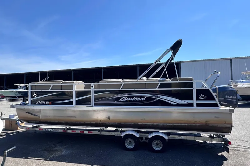 The Image of 2015 JC 24 Tri-Toon pontoon boat on trailer, featuring Yamaha engine. - 0