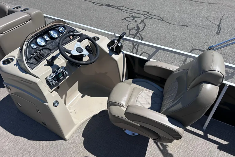 Slide: The Image of Captain's chair and dashboard of 2015 JC 24 Tri-Toon boat, featuring gauges and controls. - 12