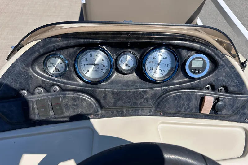 Slide: The Image of Dashboard of a 2015 JC 24 Tri-Toon boat with gauges and controls. - 13
