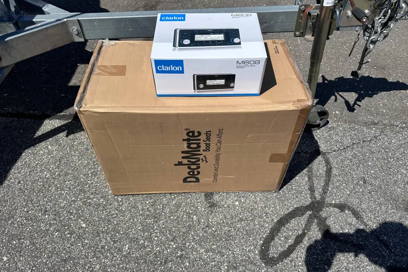 Slide: The Image of Box of DeckMate boat seats and Clarion M608 stereo on pavement. - 25