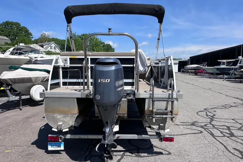 Slide: The Image of 2015 JC 24 Tri-Toon boat with Yamaha 150 engine, parked in marina. - 4