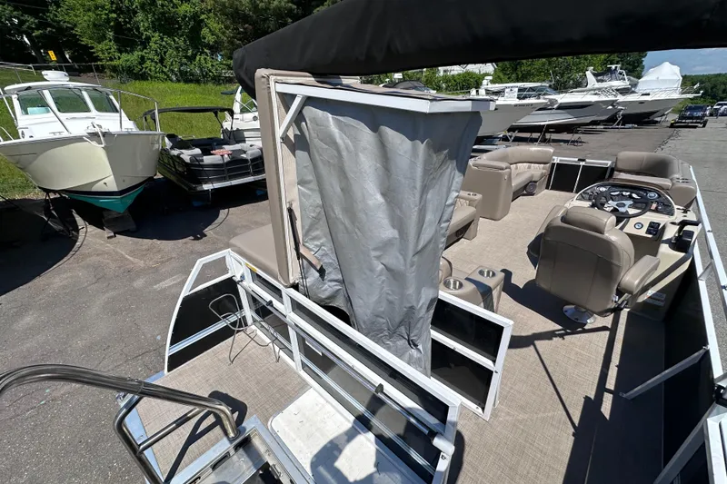 Slide: The Image of 2015 JC 24 Tri-Toon pontoon boat with spacious seating and modern helm, docked outdoors. - 7