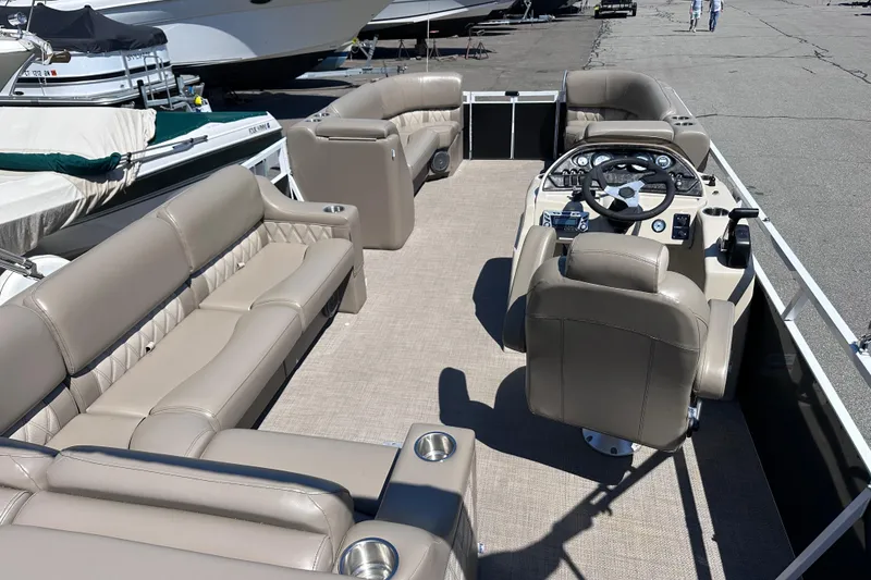 Slide: The Image of 2015 JC 24 Tri-Toon boat interior with beige seating and steering console. - 8