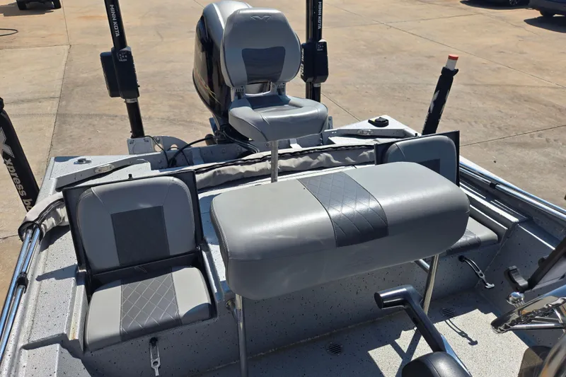 Slide: The Image of 2019 Xpress SW20B boat interior with gray seating and motor, docked on concrete. - 12