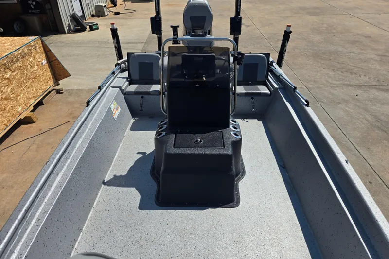 Slide: The Image of 2019 Xpress SW20B boat interior with console and seating, parked on concrete. - 7