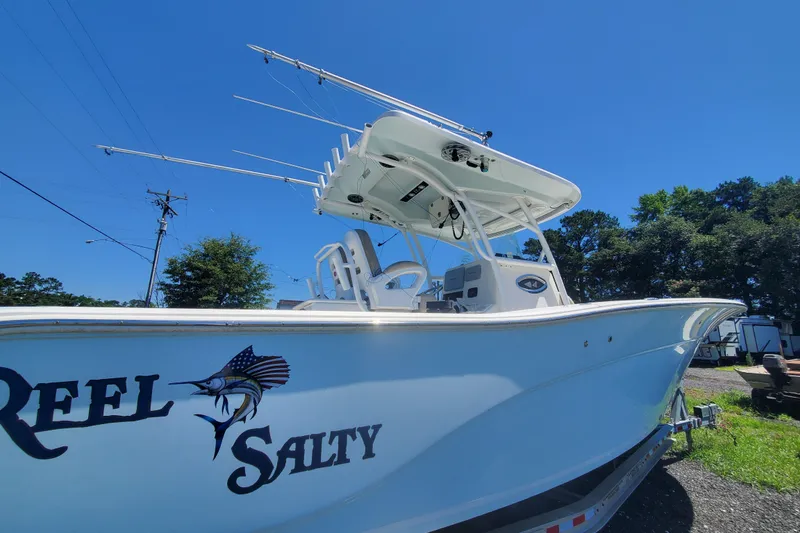 Slide: The Image of 2015 Sea Fox 286 Commander boat with "Reel Salty" decal, parked outdoors under clear blue sky. - 16