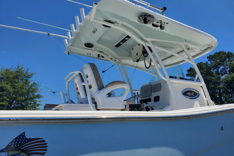Slide: The Image of 2015 Sea Fox 286 Commander boat with fishing rods and canopy under clear blue sky. - 17