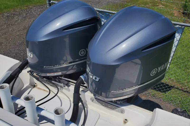 Slide: The Image of Twin Yamaha outboard motors on a 2015 Sea Fox 286 Commander boat, parked near a fence. - 28