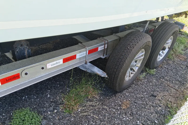 Slide: The Image of Trailer for 2015 Sea Fox 286 Commander boat with dual wheels on gravel. - 30