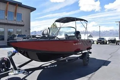 Slide: The Image of 2026 Lowe Fish & Ski 1700 boat on trailer, parked outdoors under a blue sky. - 11
