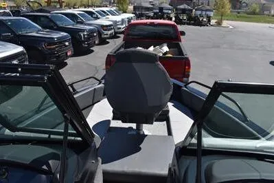 Slide: The Image of 2026 Lowe Fish & Ski 1700 boat interior with parked vehicles in the background. - 20