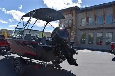 Slide: The Image of 2026 Lowe Fish & Ski 1700 boat with canopy, parked outdoors on a sunny day. - 3
