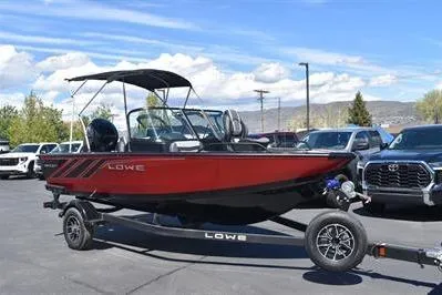 Slide: The Image of 2026 Lowe Fish & Ski 1700 boat on trailer, parked outdoors under blue sky. - 6