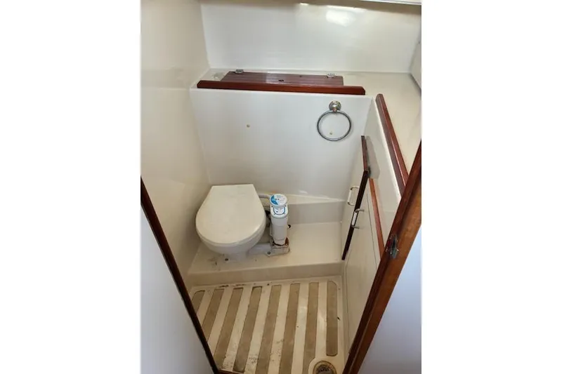 Slide: The Image of Compact bathroom in a 2003 Camano Troll boat, featuring a toilet and wooden accents. - 10
